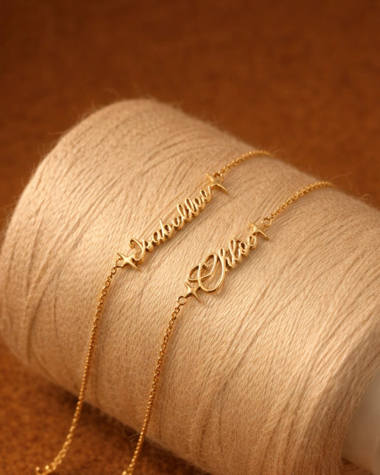 Gold name bracelet on a spool of beige thread