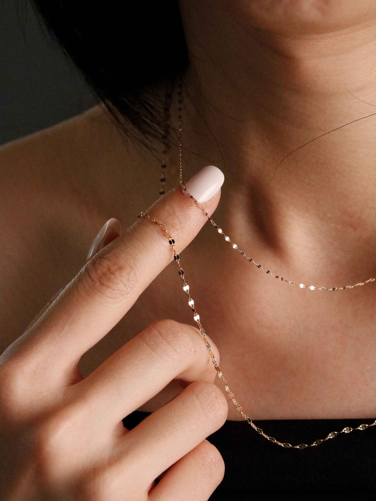 Dainty Sparkle Chain in Solid Gold worn at the neck, diamond-cut links catching the light