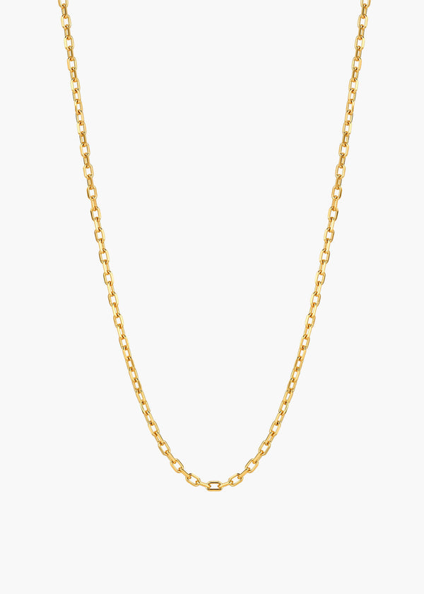 A delicate gold chain necklace with a classic curb link design, displayed against a clean, light off-white background.