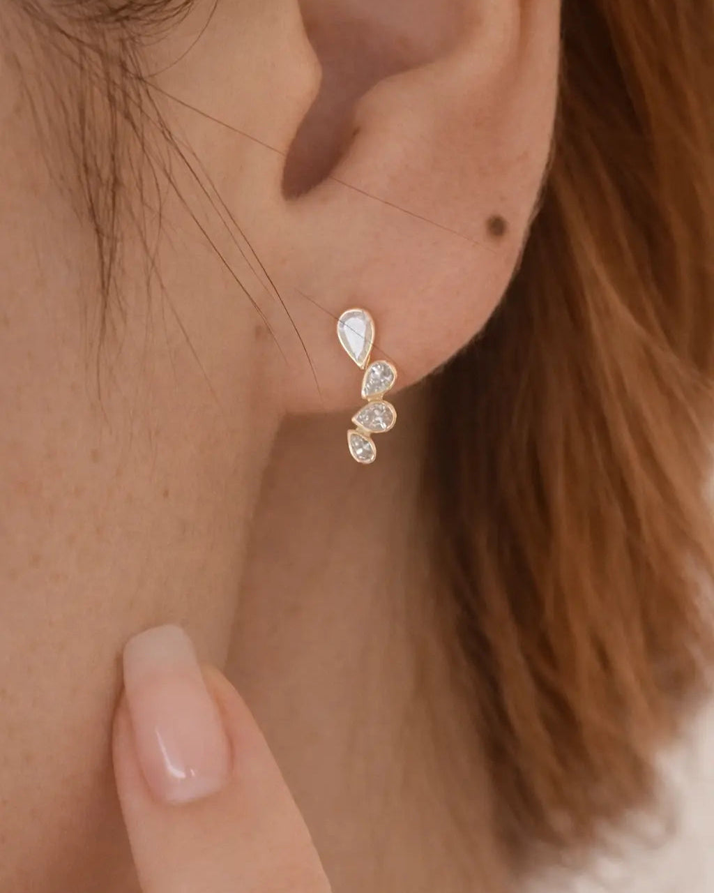 Close-up of an ear wearing a delicate earring with a blurred background