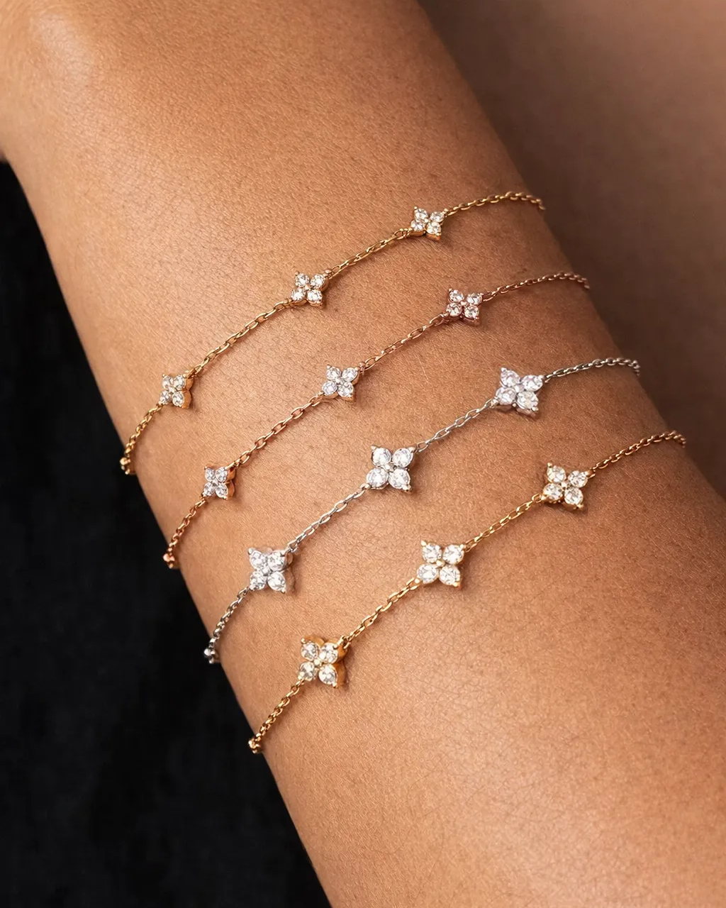 Two delicate bracelet sets on a person's wrist against a neutral background