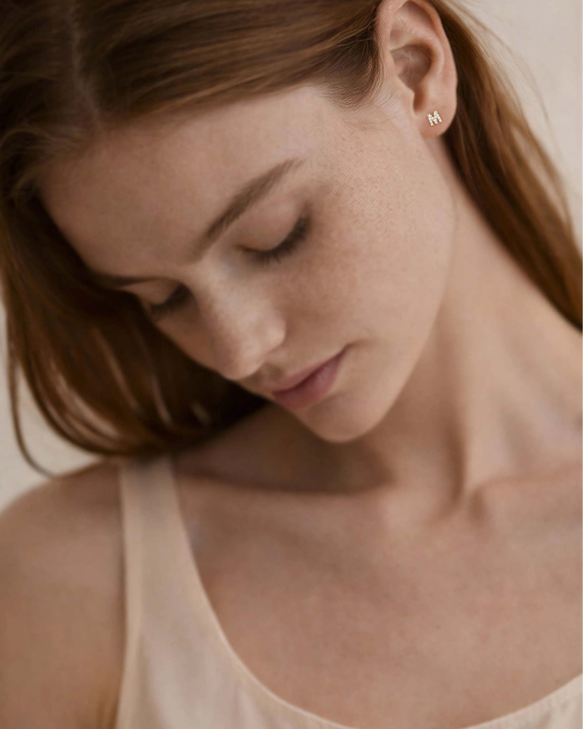 Woman wearing a beige tank top with a neutral background