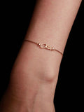 gold bracelet with 'Chloe' on a wrist against a black background