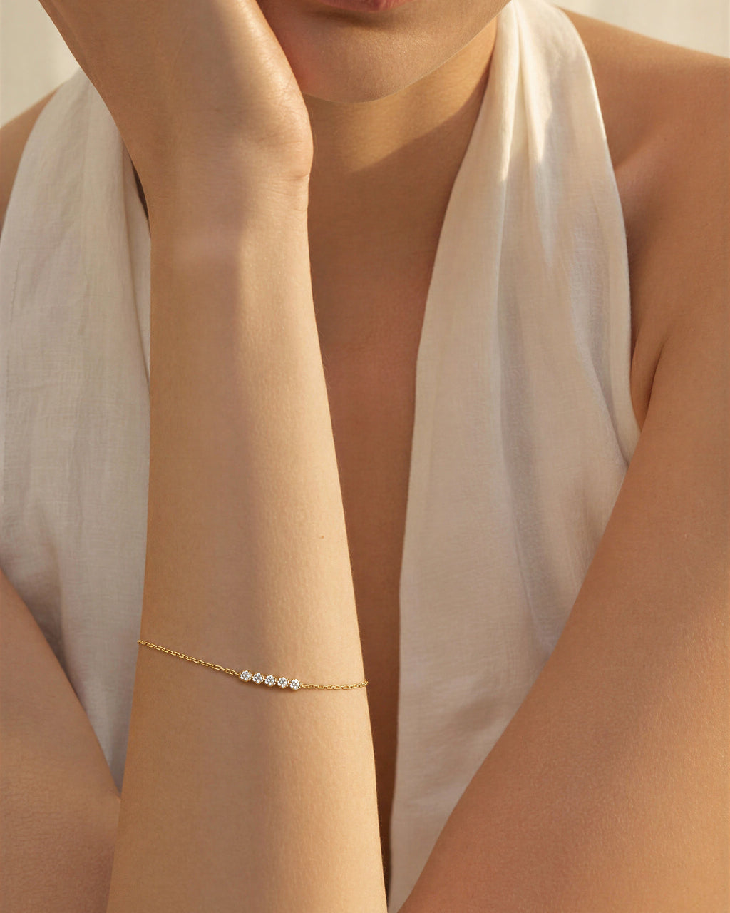 Close-up of a person wearing a delicate bracelet on a blurred background