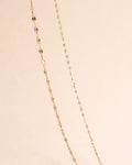 Gold chain necklace on a beige background