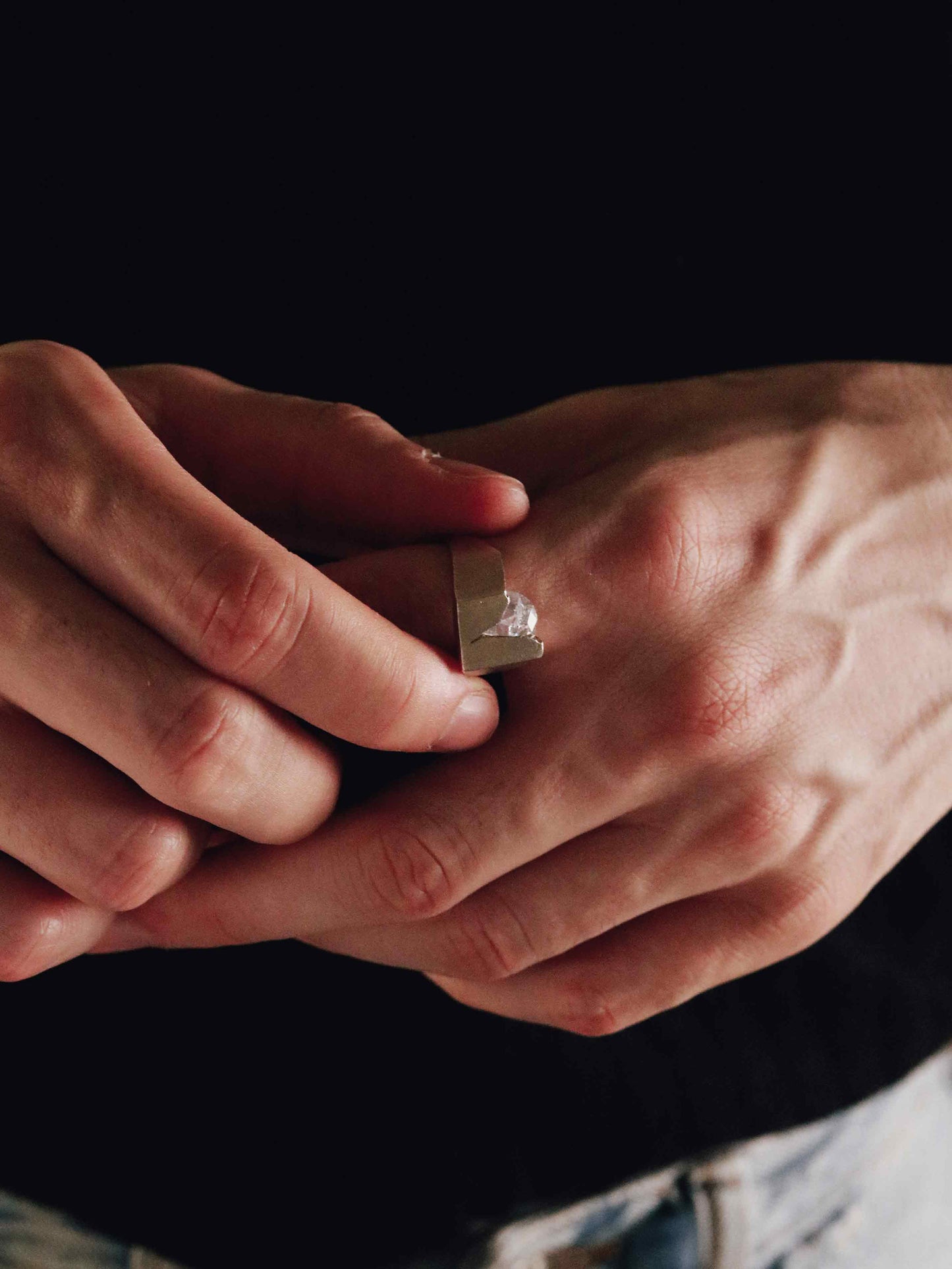 him wearing a silver ring with a zirconia gem 