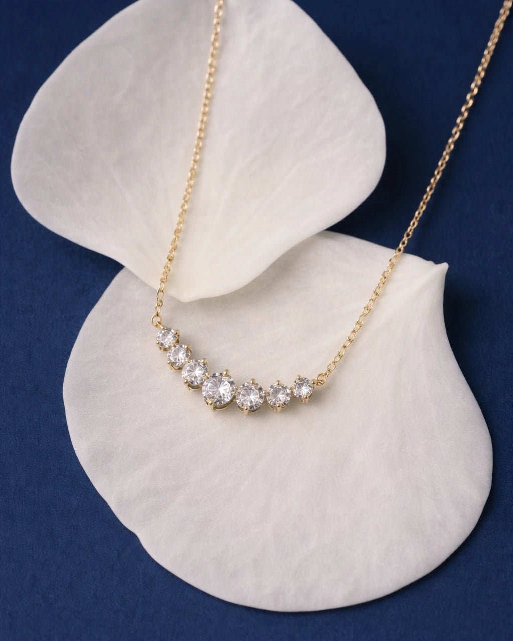 Gold necklace with diamonds on a white shell against a blue background