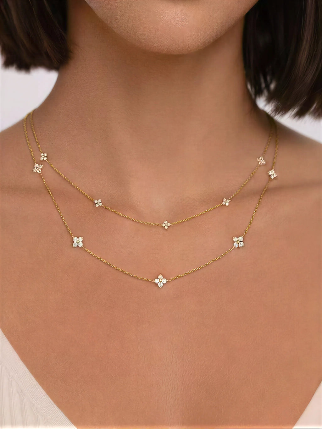 Gold necklace with floral pendants on a person's neck
