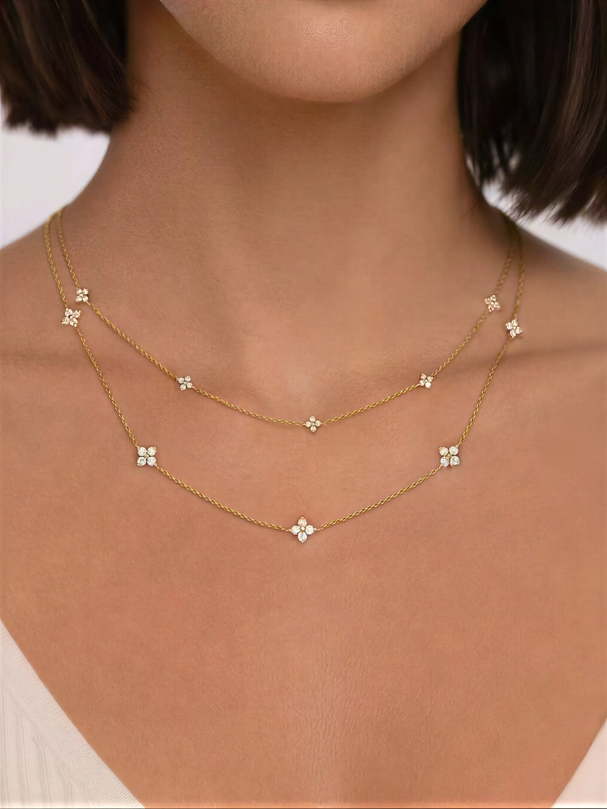 Gold necklace with floral pendants on a person's neck