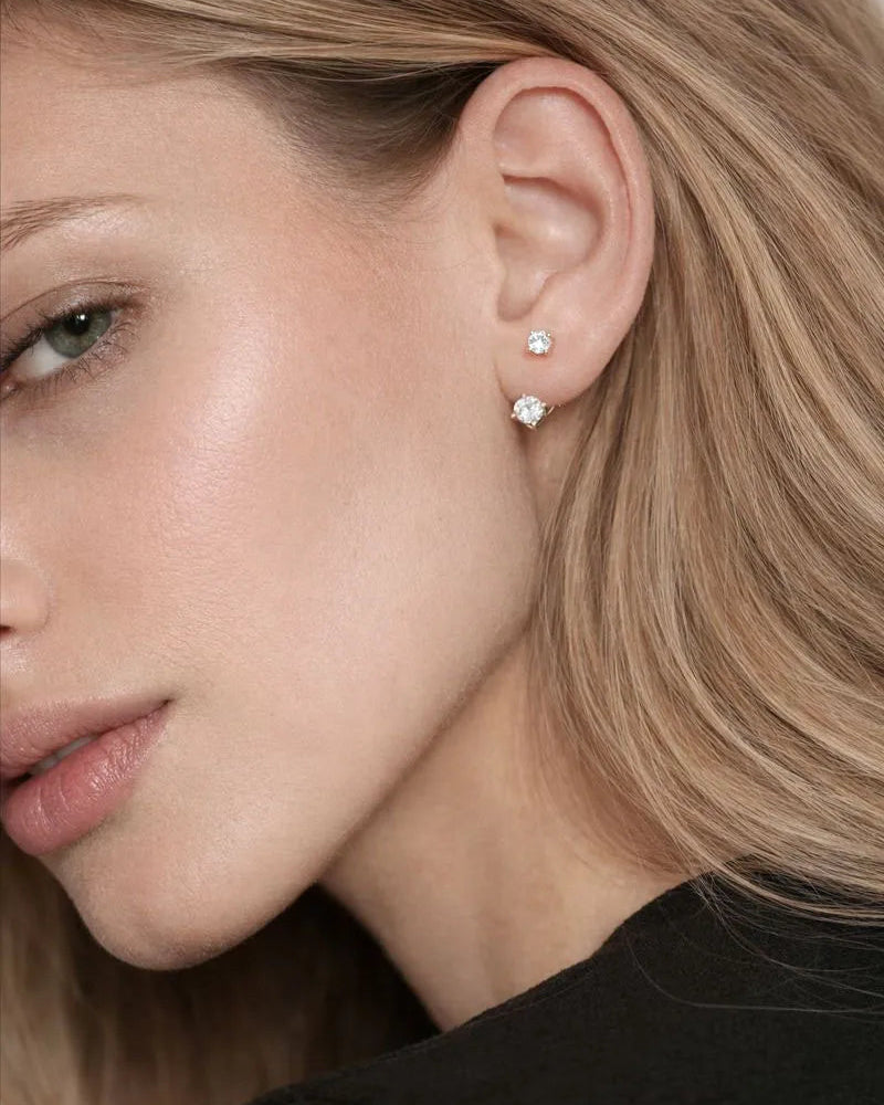 Close-up of a woman's ear with diamond stud earrings