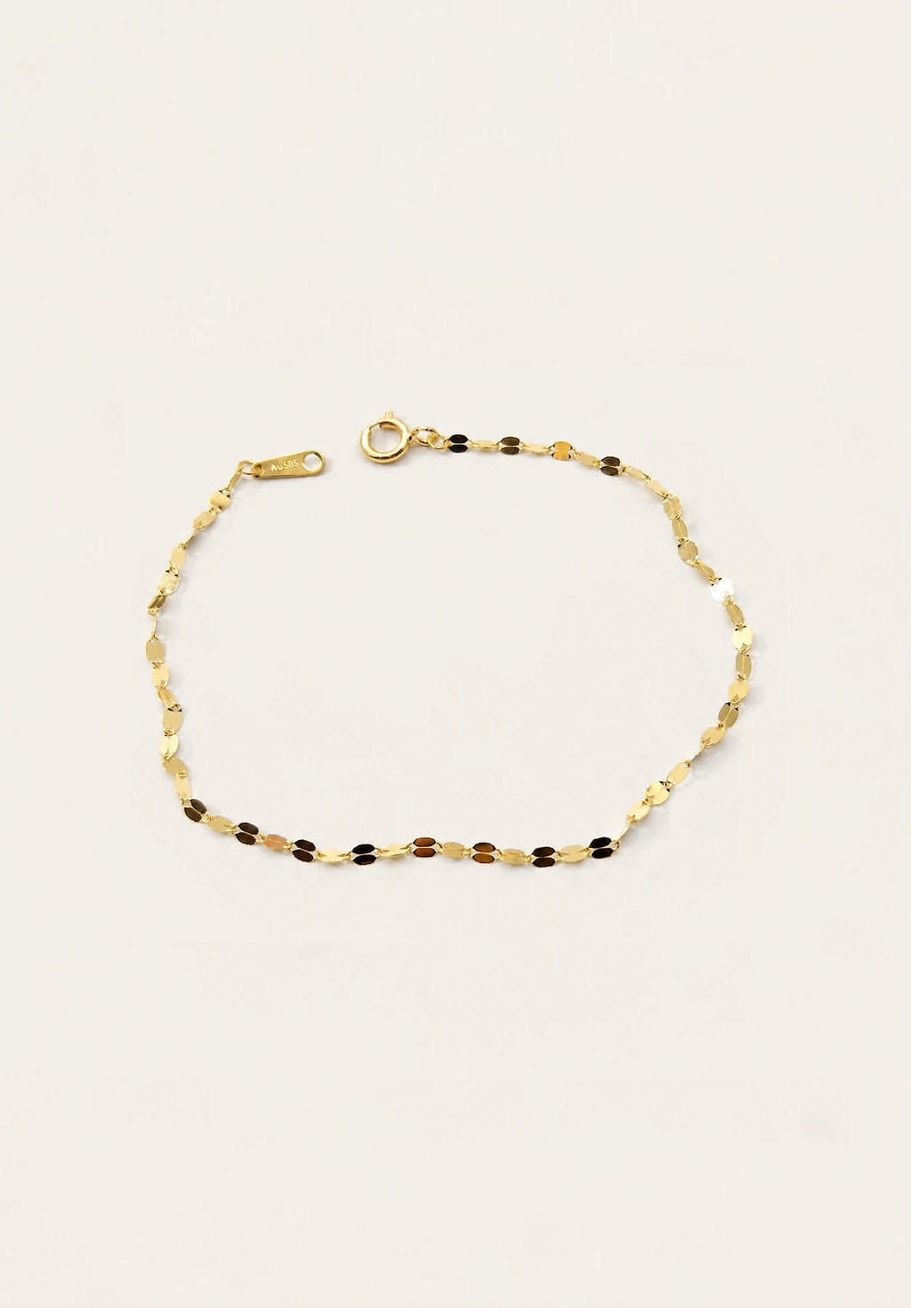 A delicate gold chain bracelet with alternating small gold and dark brown beads, displayed on a clean off-white background.