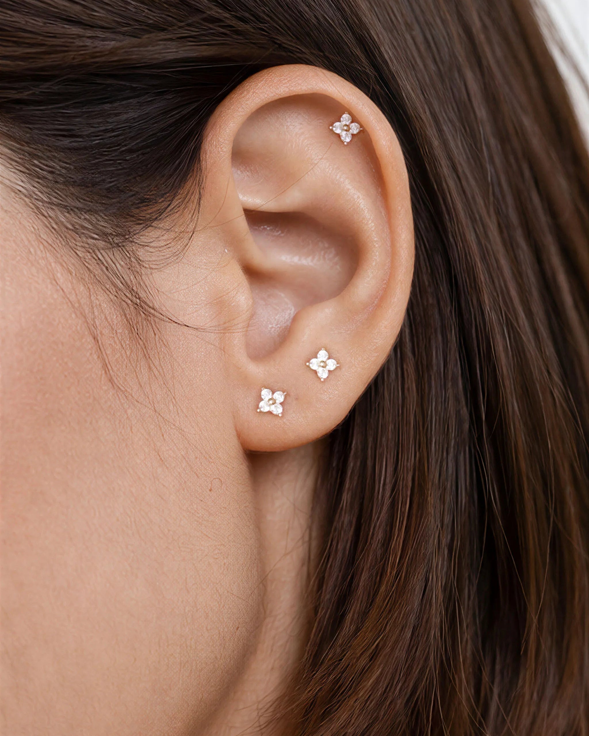 Close-up of an ear wearing a delicate earring with small embellishments.