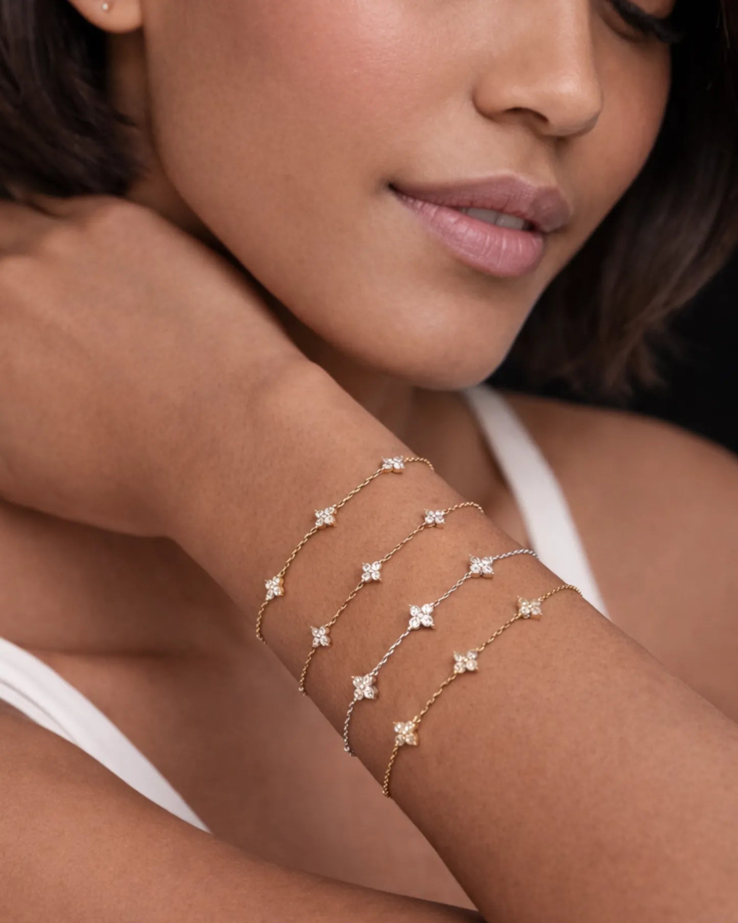 Close-up of a woman's arm wearing a delicate gold bracelet with star-shaped stones.