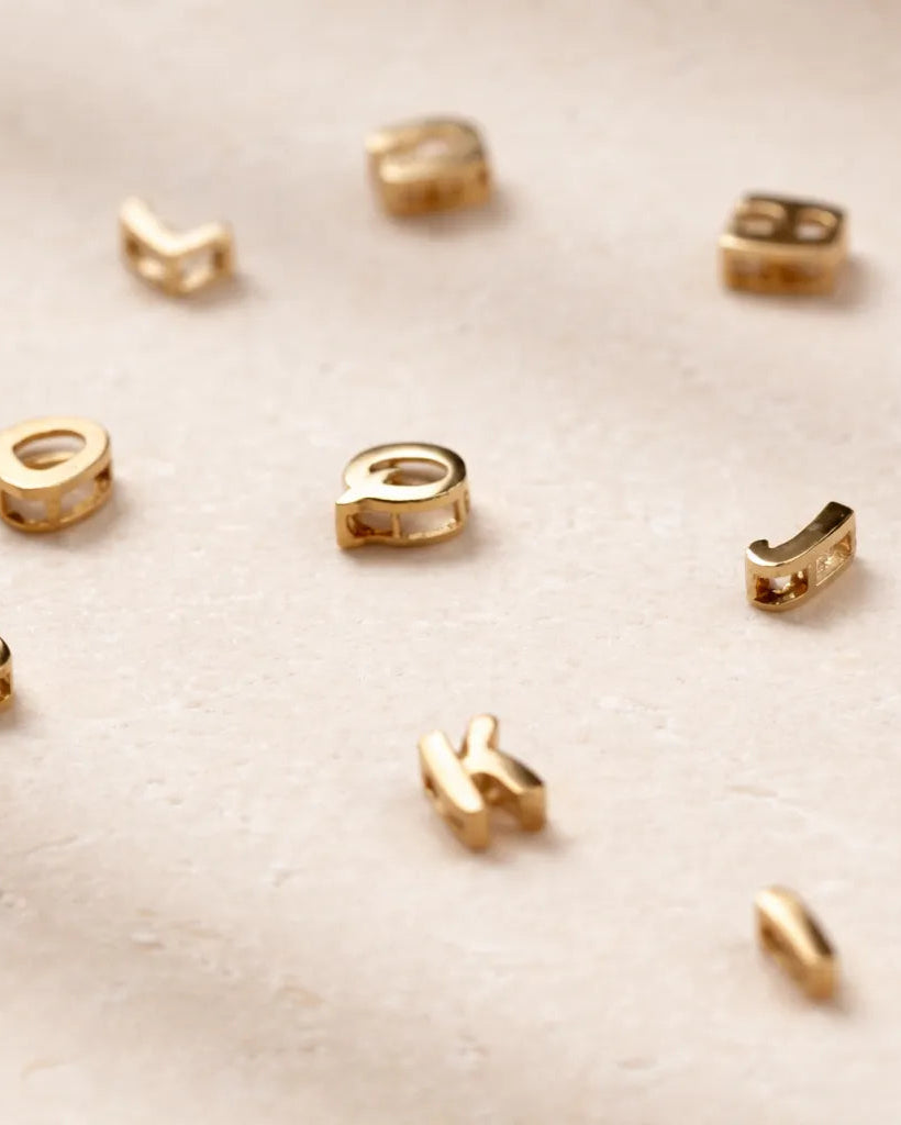 Gold jewelry components on a beige fabric background