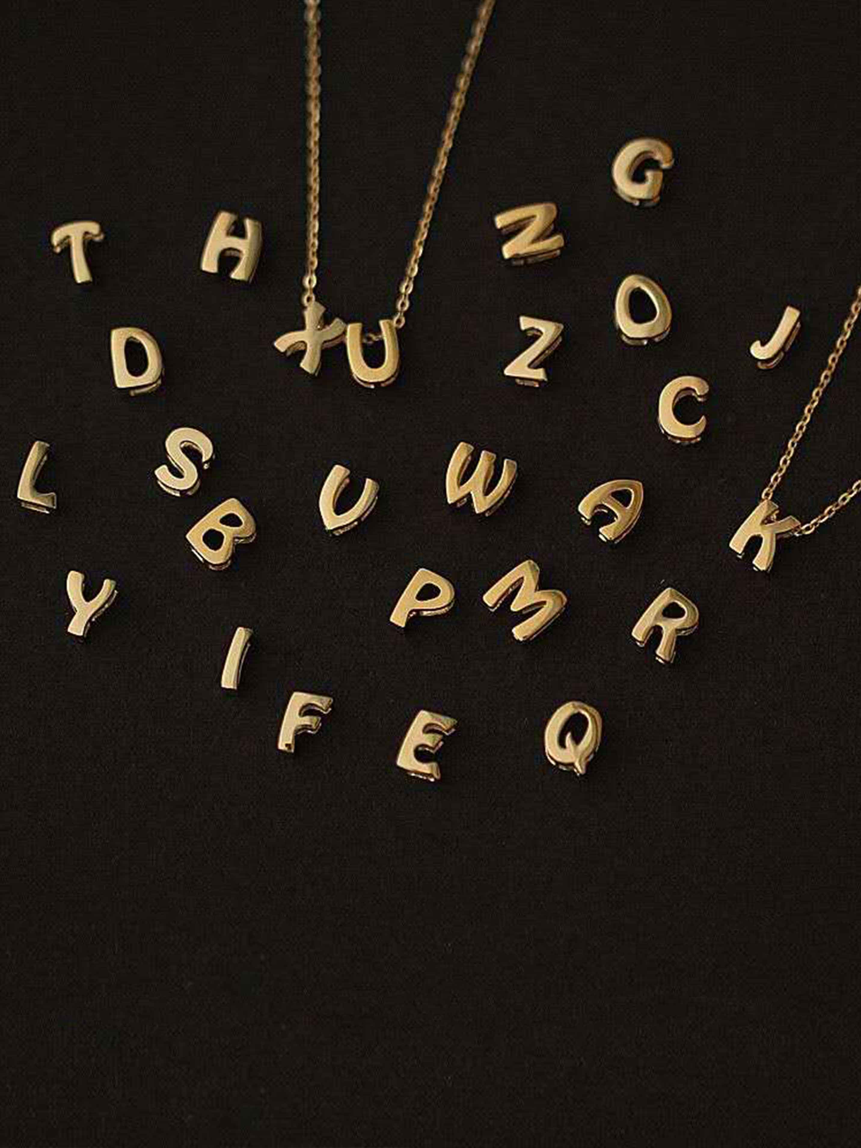 Gold letter pendants on a black background