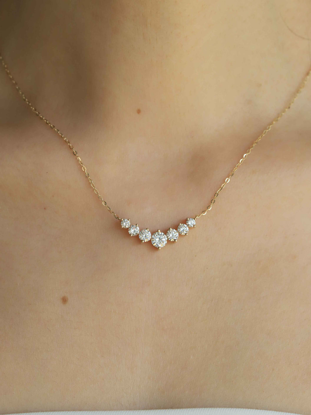 Gold necklace with diamonds on a person's neck