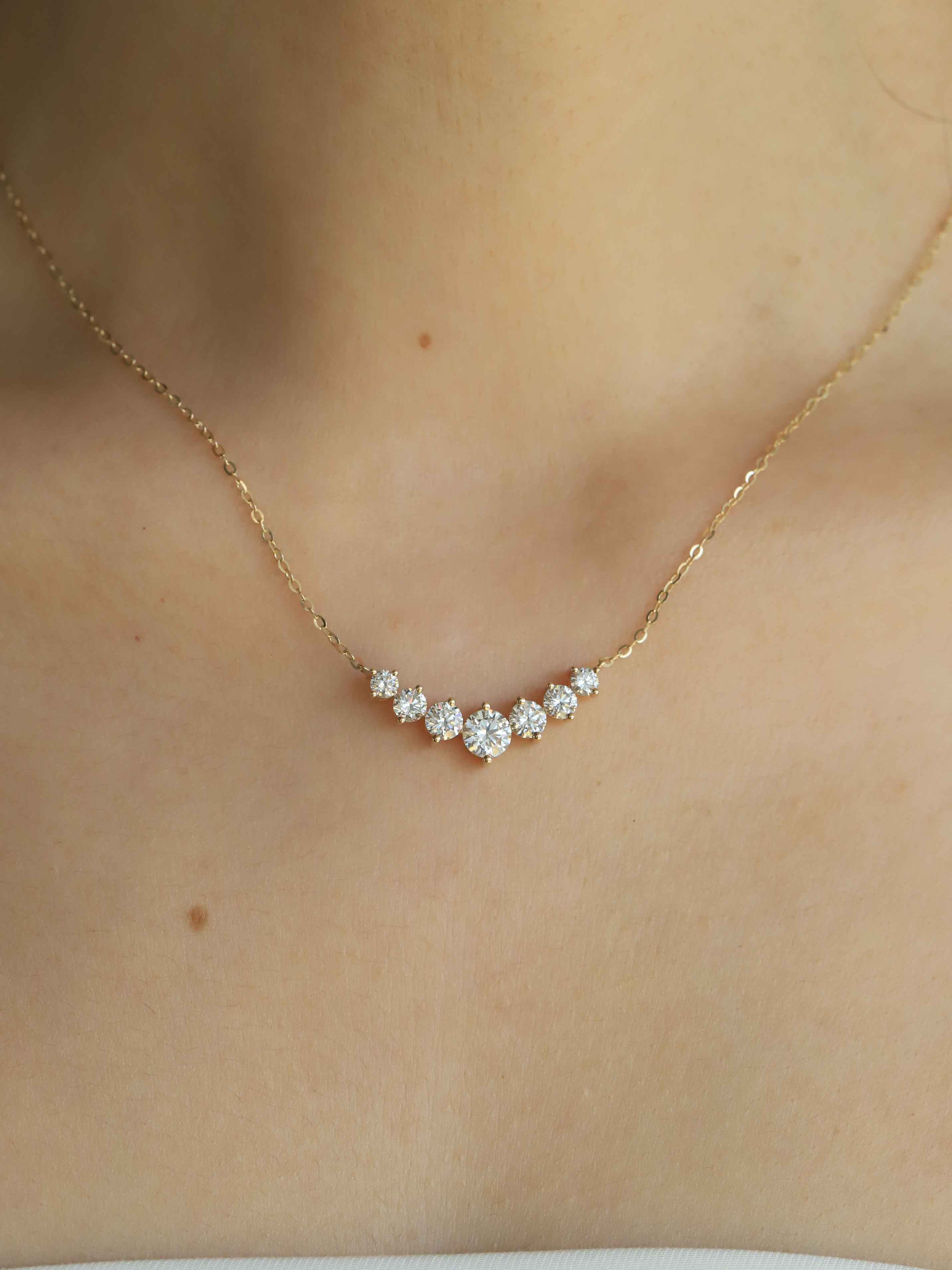Gold necklace with diamonds on a person's neck