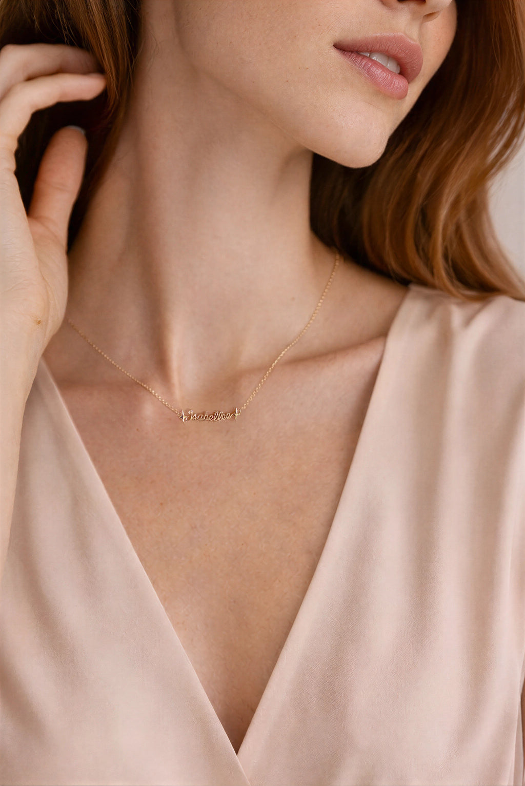 Close-up of a person wearing a delicate gold necklace with a minimalistic pendant.
