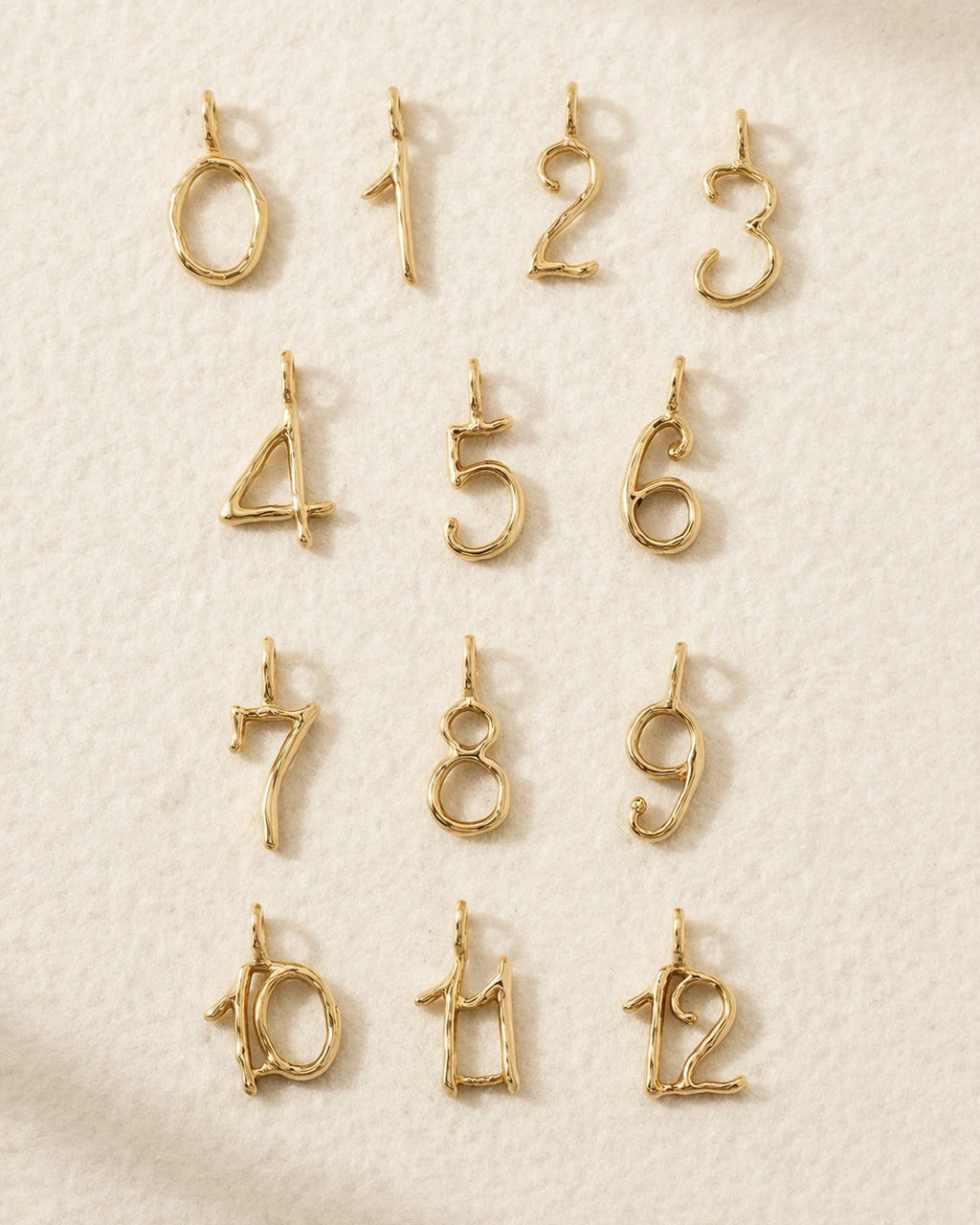 Gold number charms on a textured beige background