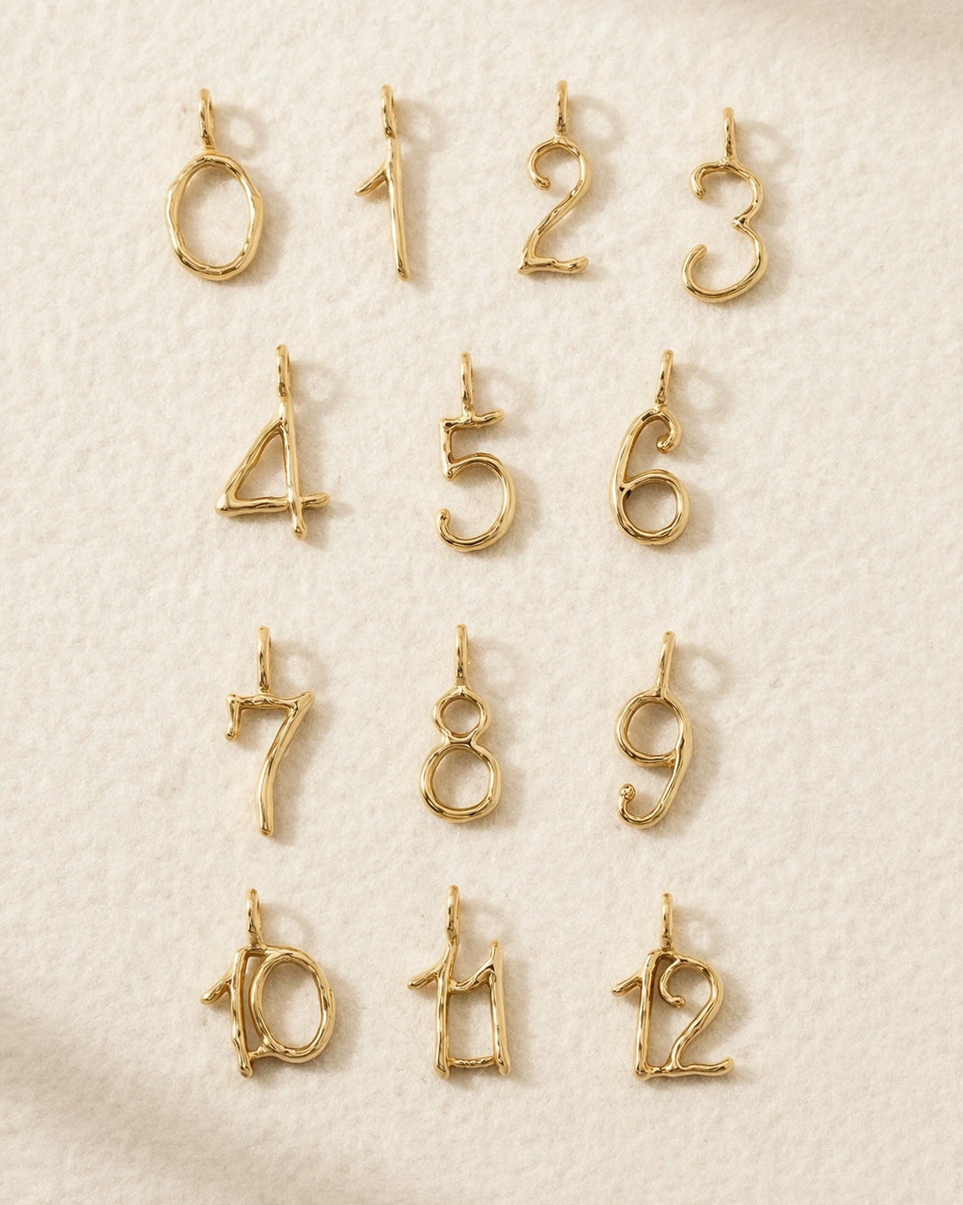 Gold number charms on a textured beige background