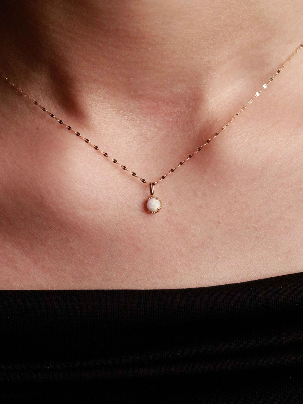 gold necklace with a small pendant on a person's neck