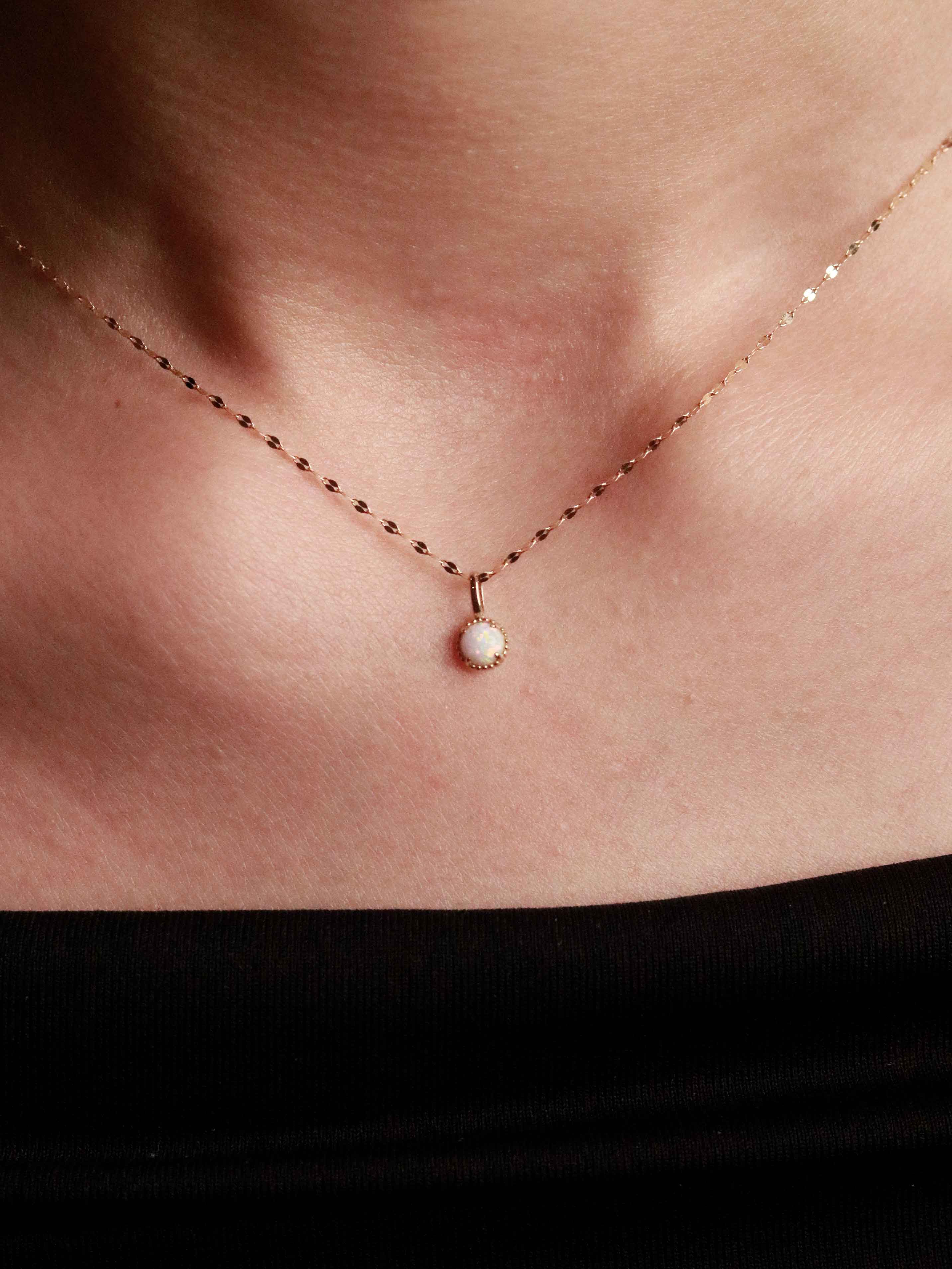 gold necklace with a small pendant on a person's neck
