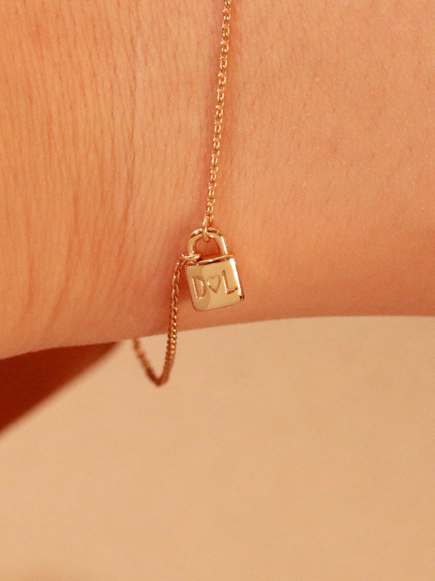 initials engraved on a  14k gold padlock 