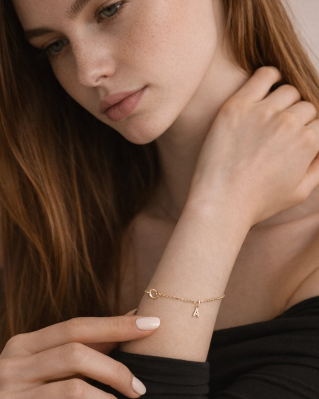 Woman wearing a gold bracelet with a delicate chain design.