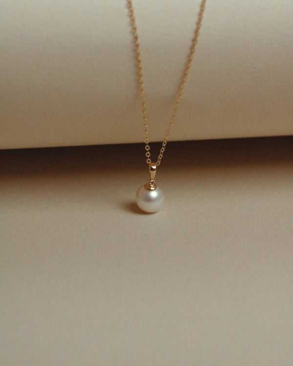 Pearl pendant necklace in solid gold worn on the neck