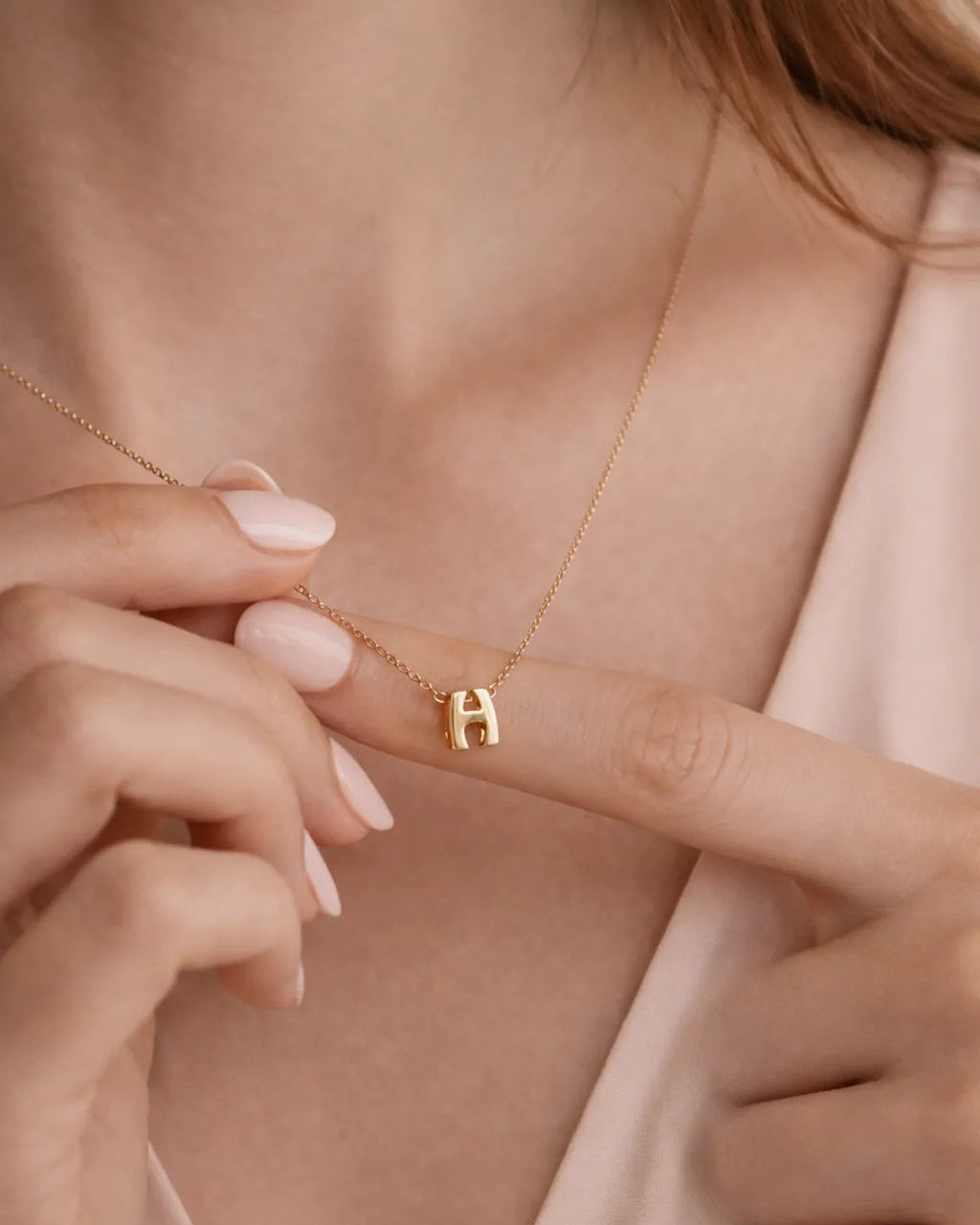 Close-up of a person wearing a gold necklace with a small pendant.